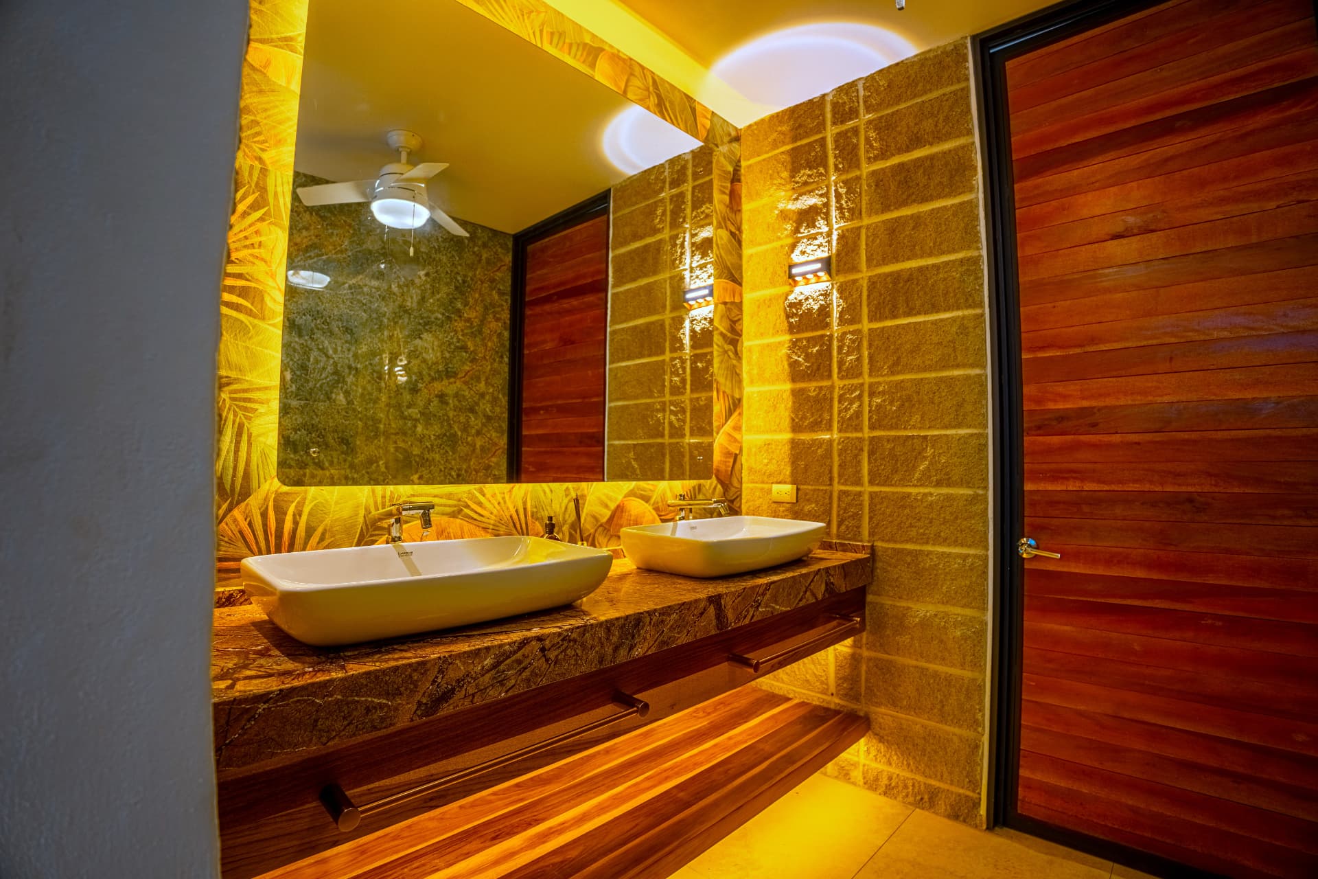 Double vessel sinks on a marble vanity with warm lighting