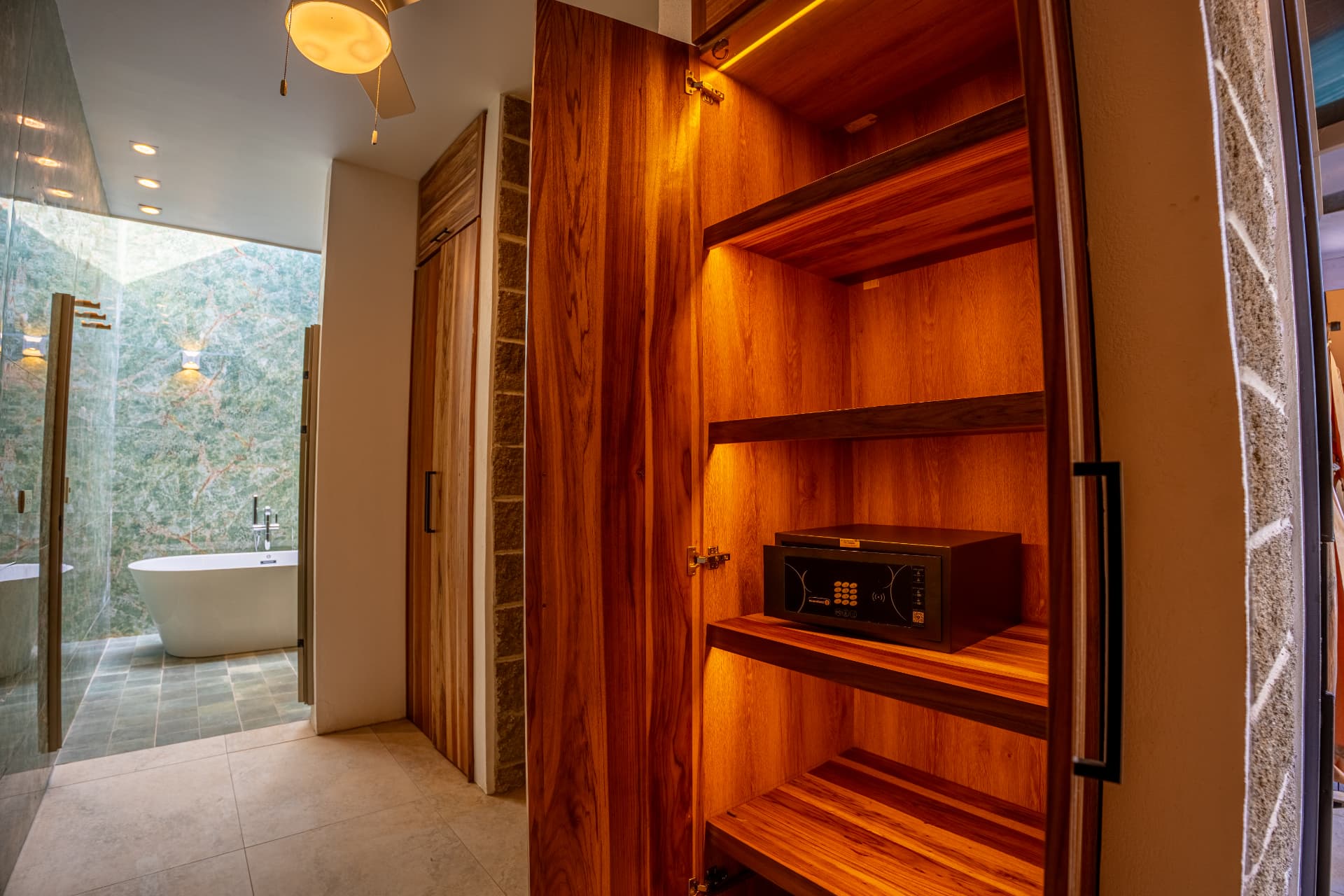 Teak closet with in-room safe beside the bathroom