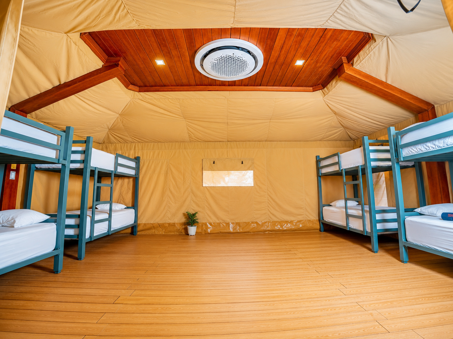 Eight-bed tented dorm interior with teal bunk beds