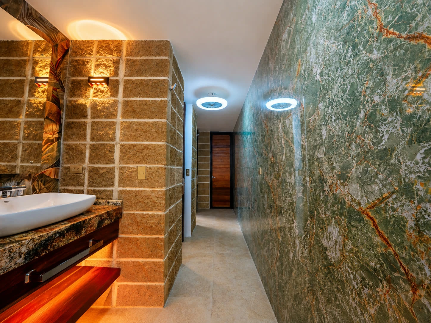 A private glamping bathroom with a walk-in rain shower and stone wall finishes