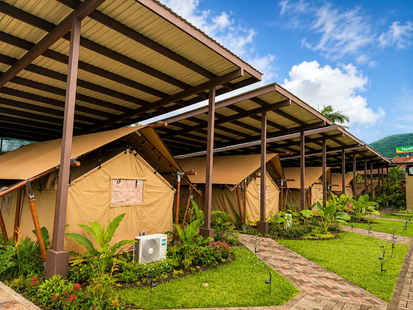 Golden canvas tents and covered pathways surrounded by tropical planting