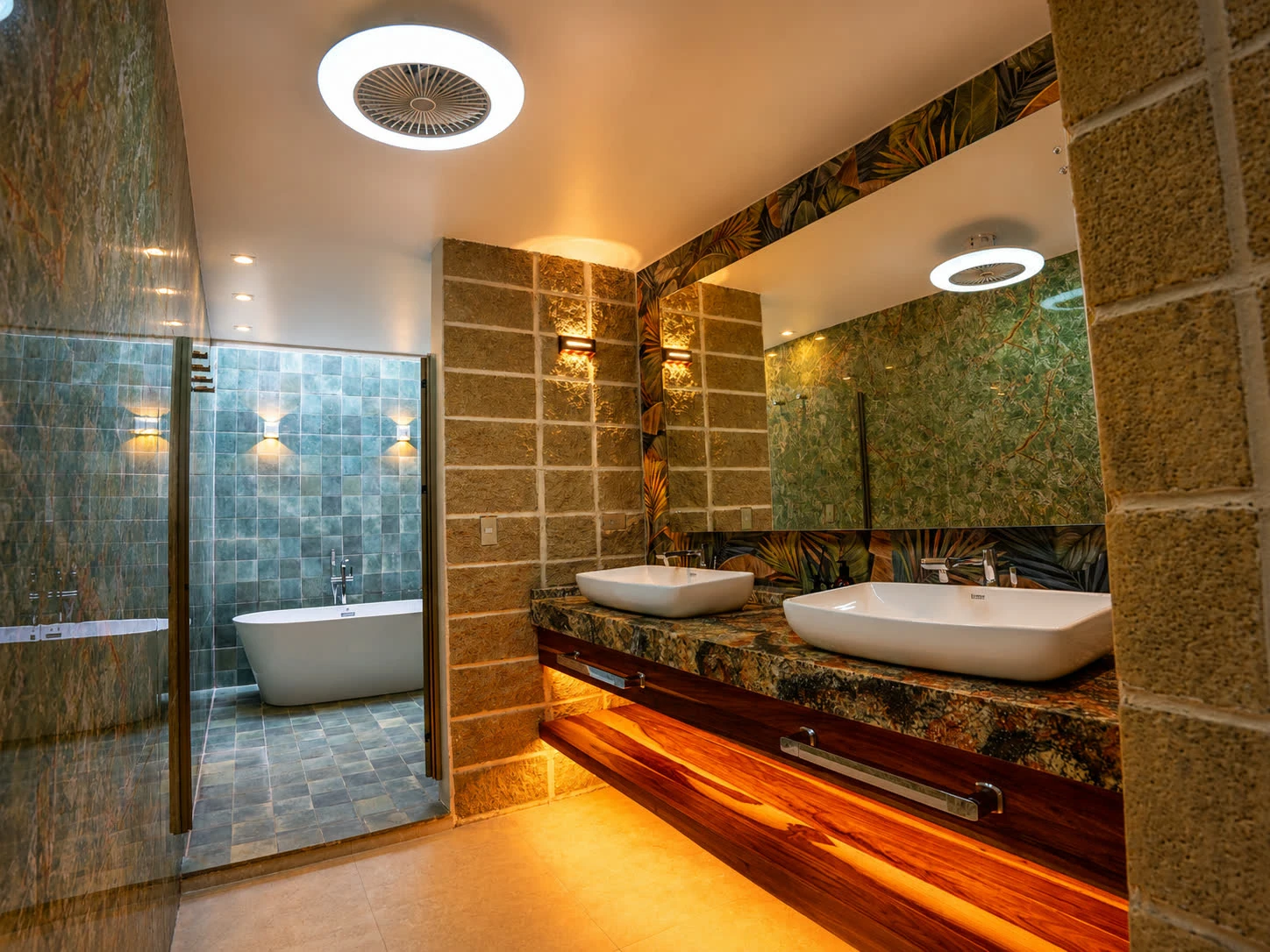 A spacious private glamping bathroom with two vanity mirrors, stone finishes and warm lighting